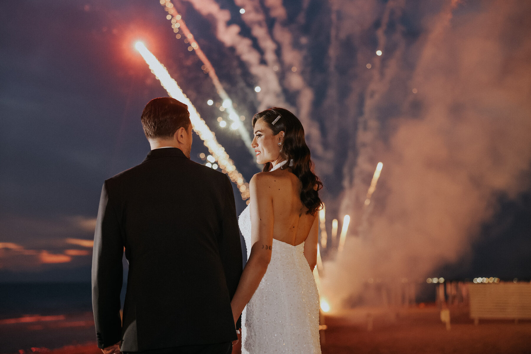 Sposi davanti ai fuochi d'artificio sulla spiaggia