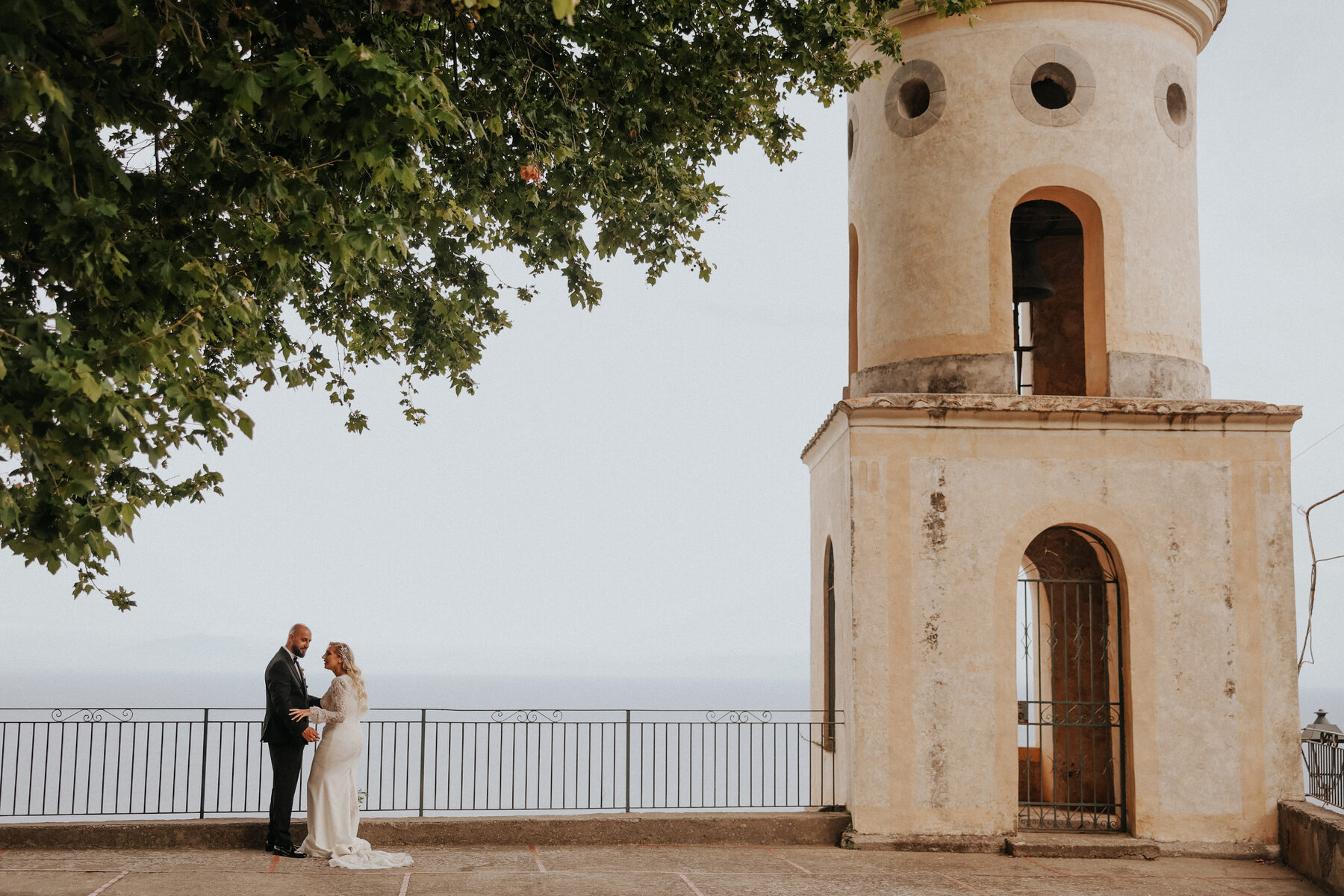 Sposi accanto al campanile con il mare della Costiera