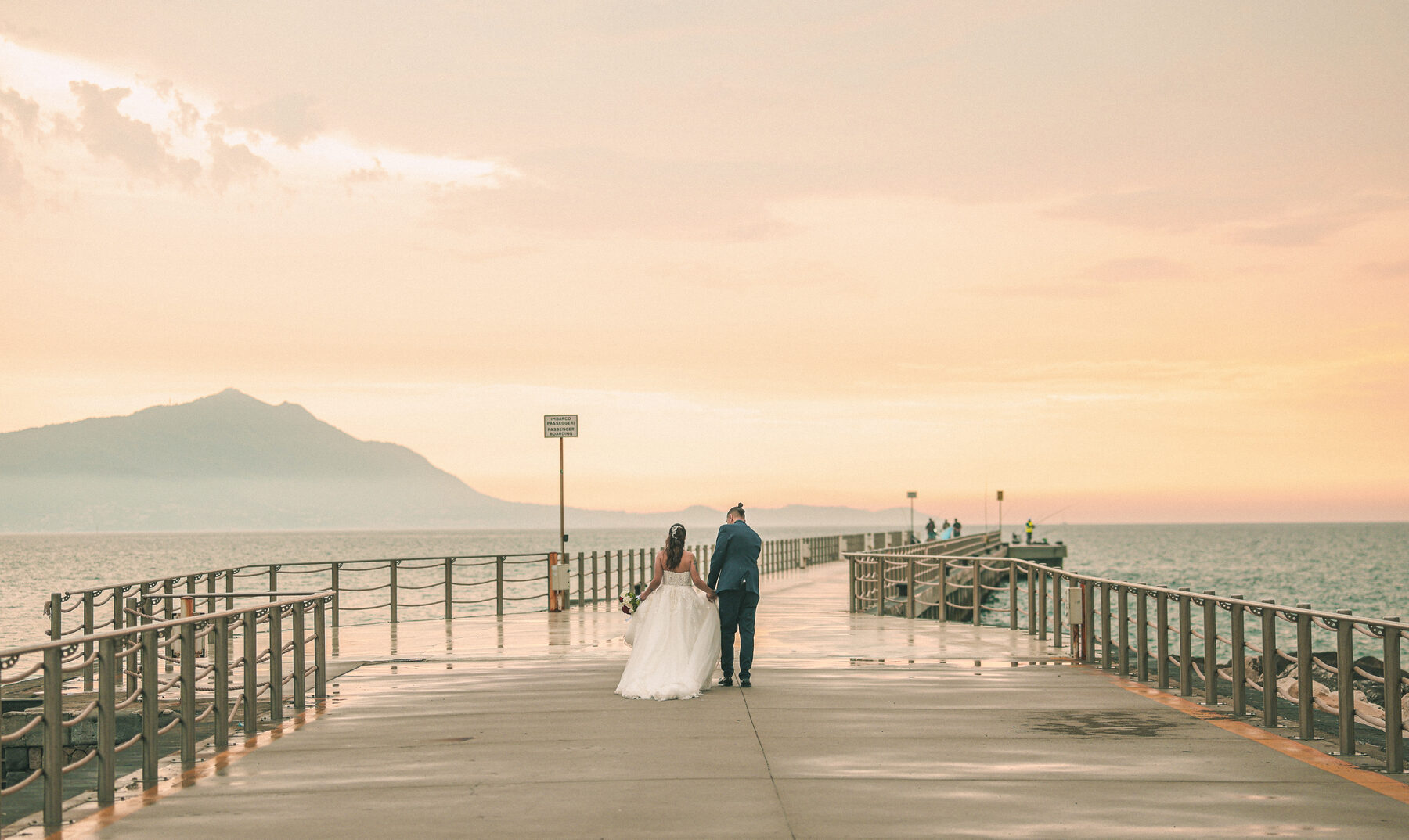 Sposi sul pontile al tramonto con Ischia all'orizzonte