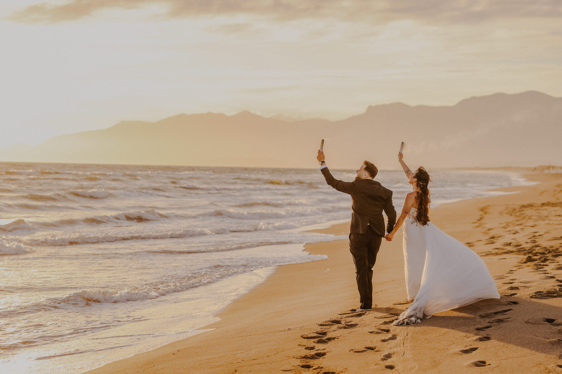 Sposi con le stelline accese sulla spiaggia al tramonto